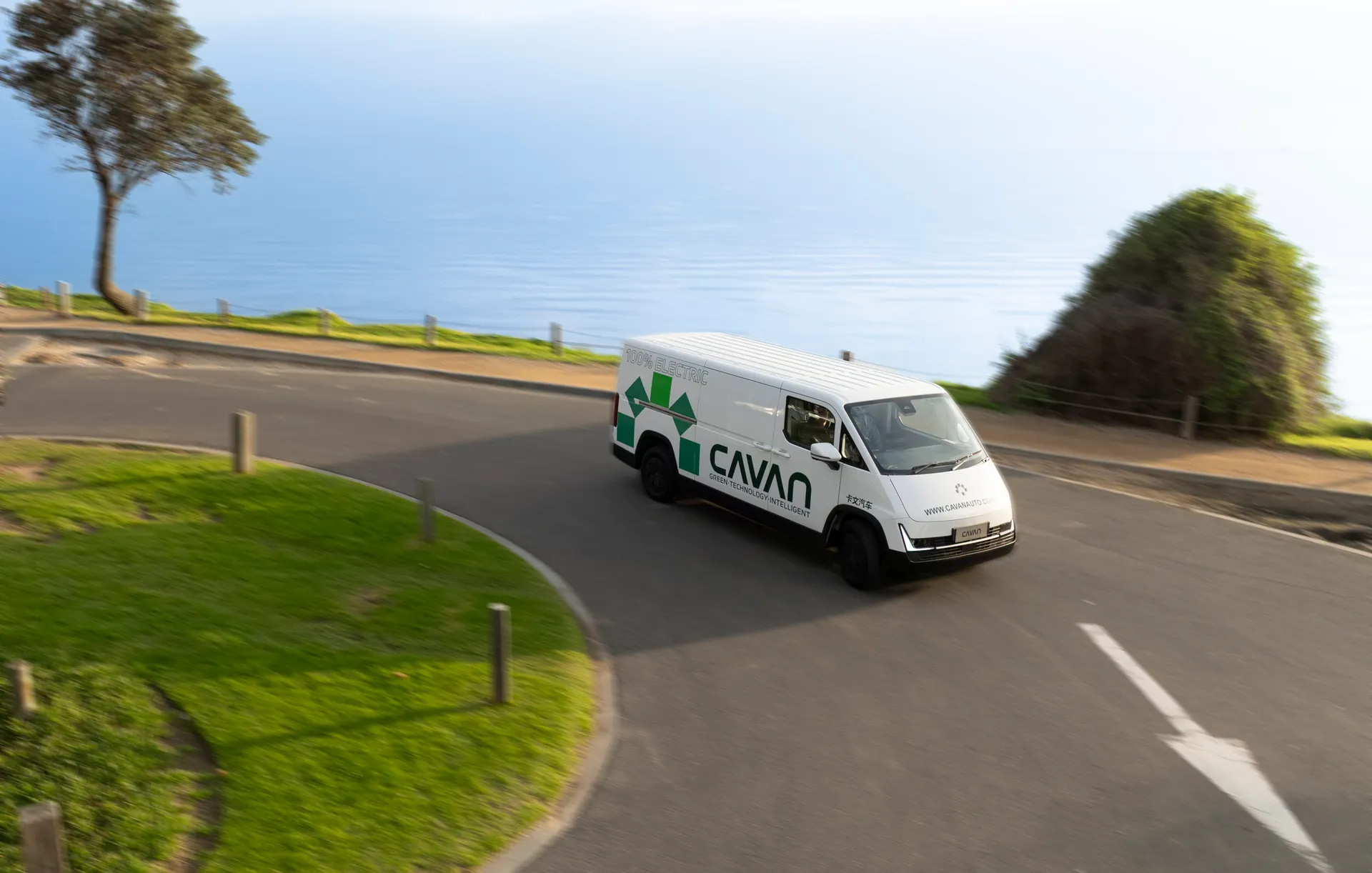 A Cavan electric van climbing a coastal lookout road above open water
